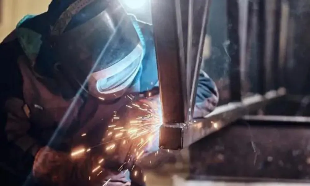 metalúrgico utilizando equipamento de proteção para fazer a solda